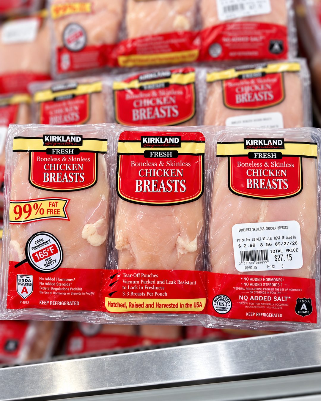 Packages of Kirkland boneless skinless chicken breasts in the Costco refrigerated case.