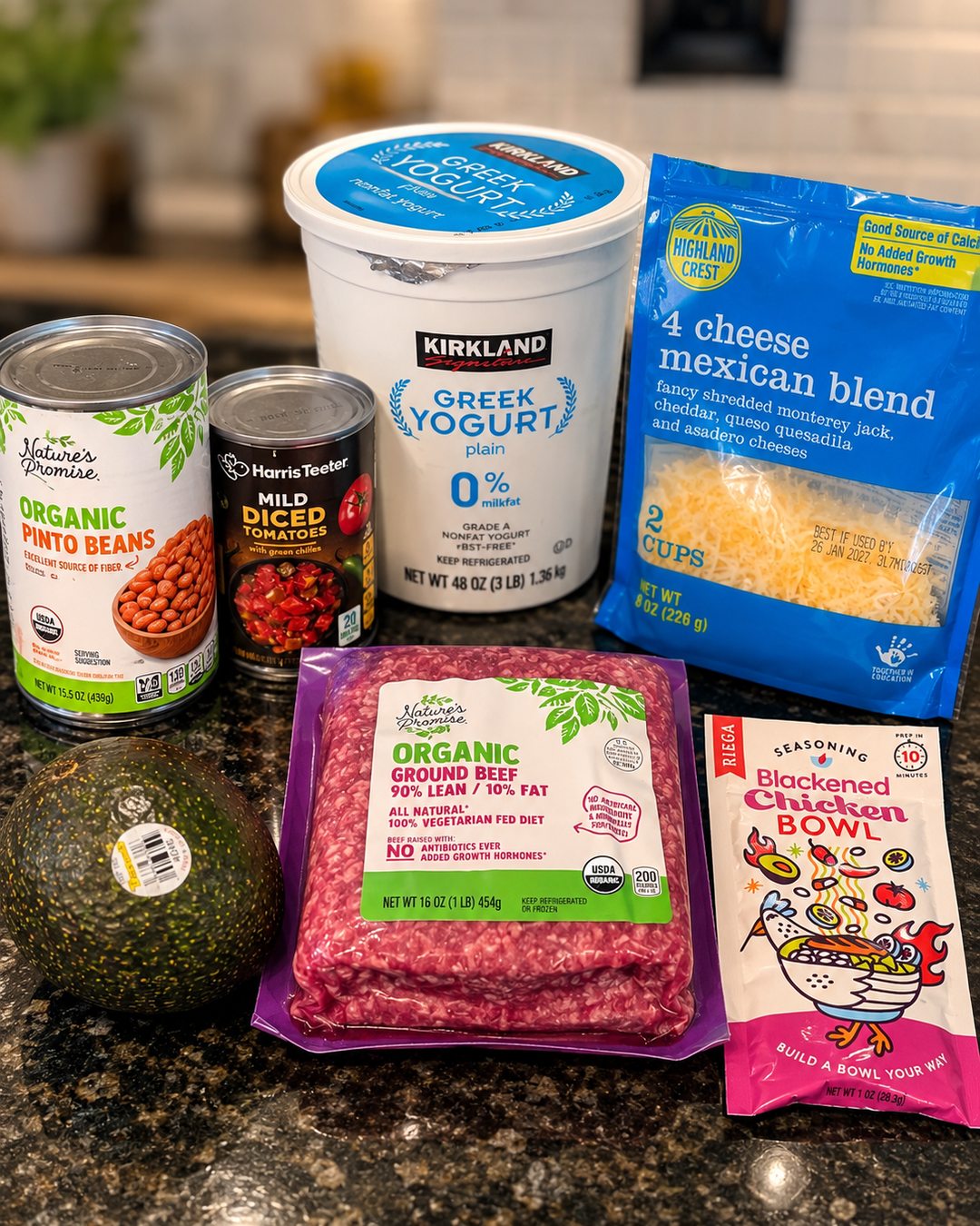 Ingredients for the Easy Protein Bowl photographed with lean ground beef, pinto beans, diced tomatoes, Greek yogurt, shredded cheese, seasoning, and avocado.